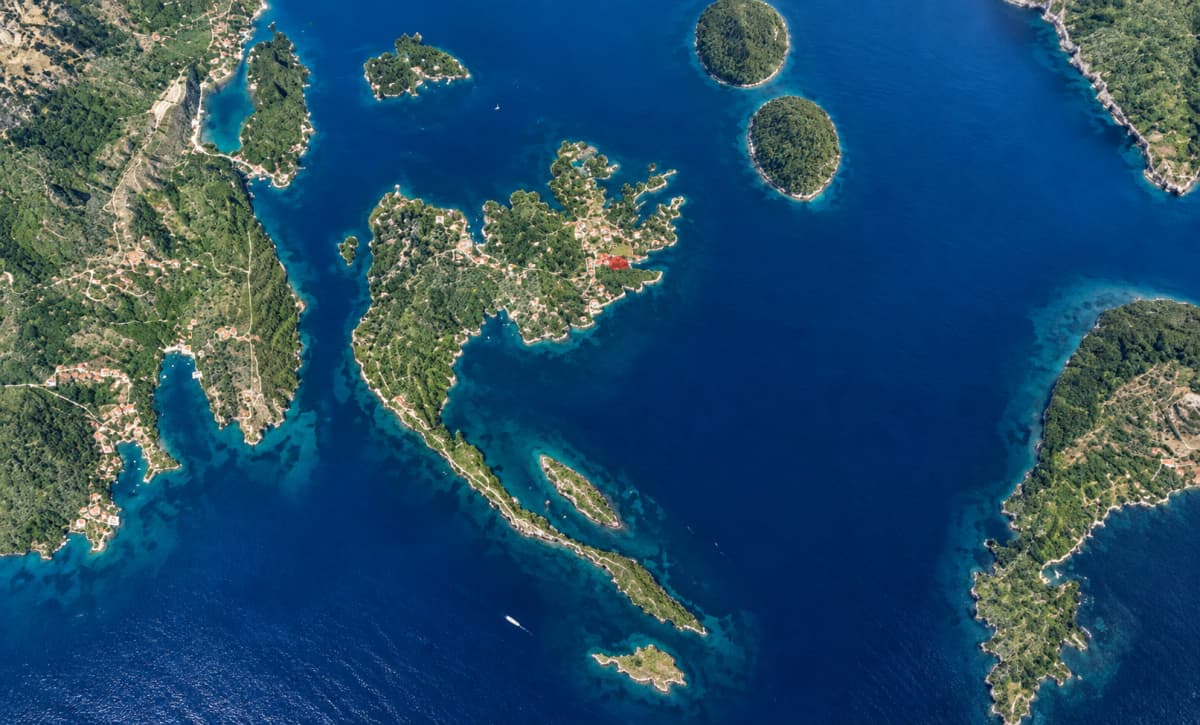 Εναέρια άποψη ενός μεγάλου πράσινου νησιού με μια ελικοειδή χερσόνησο που εκτείνεται στη θάλασσα.