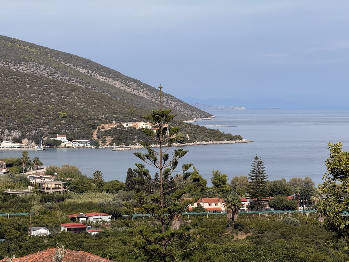 Εξωτερική θέα από ψηλά προς τη θάλασσα, τους λόφους, τα σπίτια και τα δέντρα.