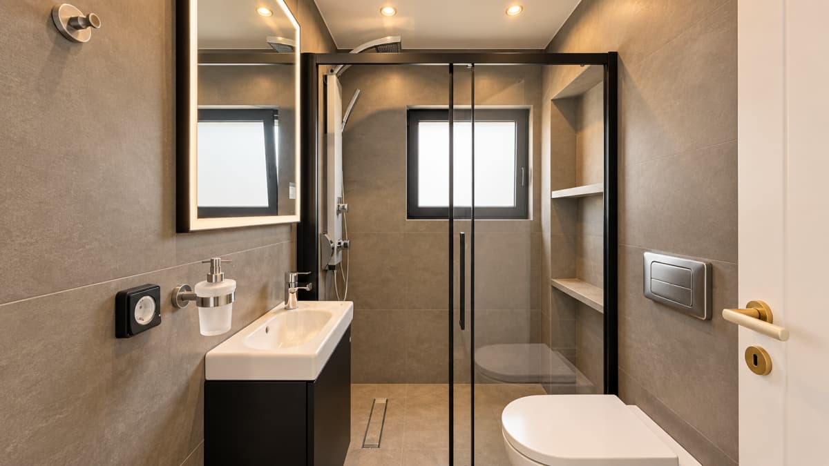 Modern bathroom with a shower, sink, and toilet.