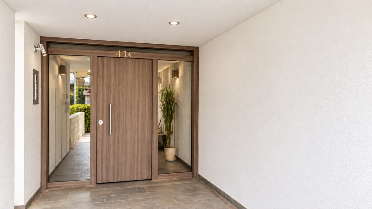 Building entrance featuring a wooden front door, glass sidelights, and house number 41A above.