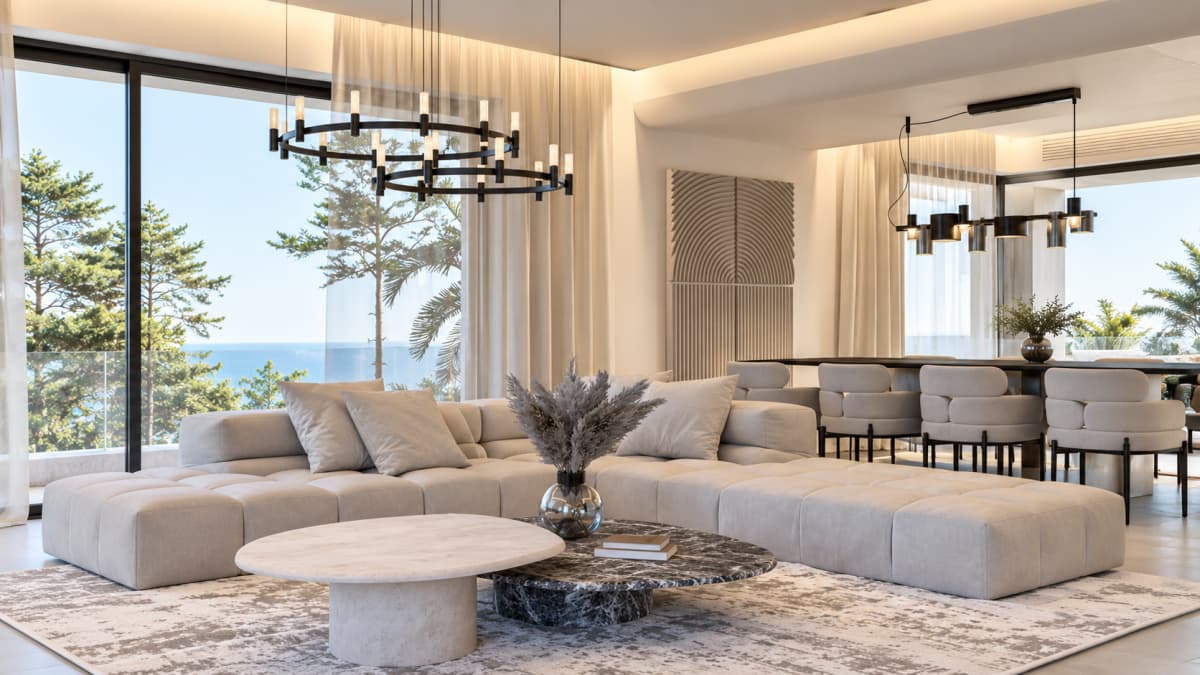 A modern living room featuring a large beige sectional sofa, a marble coffee table, floor-to-ceiling glass windows with a sea view, and a dining area in the background.