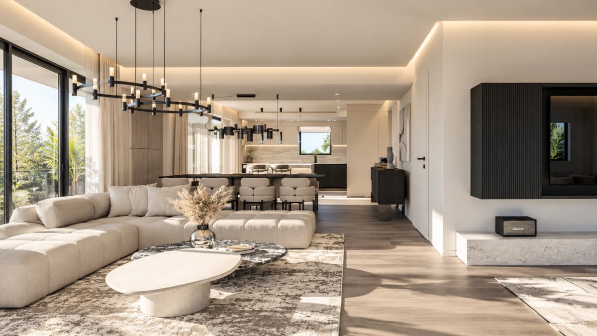 Open-plan living room with a large light-colored sectional sofa, nested coffee tables, a dining area in the background, and a modern black entertainment unit on the right wall.