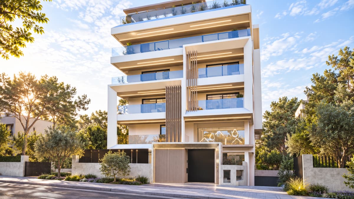 Modern white multi-story apartment building with balconies, wooden louvers, integrated lighting, and a ground-floor gate alongside trees and a paved street.