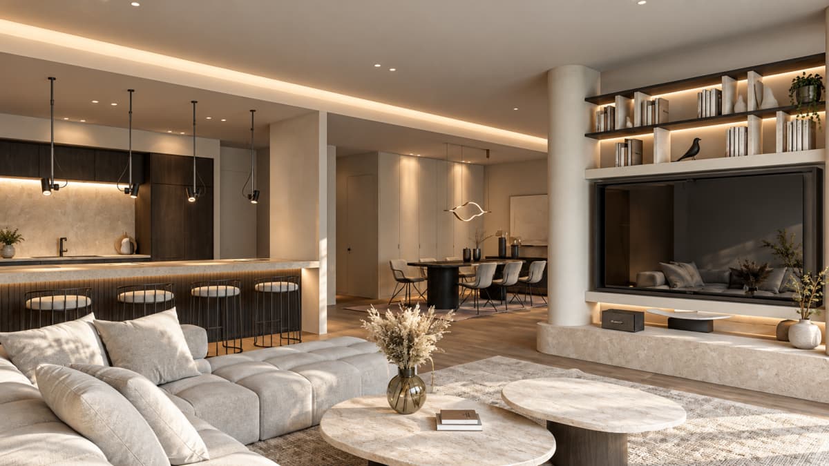 An open-plan living room and kitchen interior features a sectional sofa, two round marble coffee tables, a large wall-mounted television, built-in shelving, and an adjacent kitchen island with bar stools.