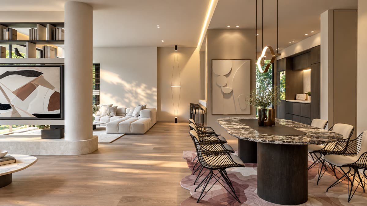 An open-plan interior features a dining area with an oval marble table on the right, a living area with a white sectional sofa in the background, and a TV unit with a prominent round support column on the left.