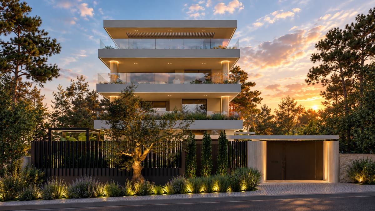 Exterior view of a four-story modern building with balconies, glass railings, and lighting, behind a metal fence and gate on the street at dusk.