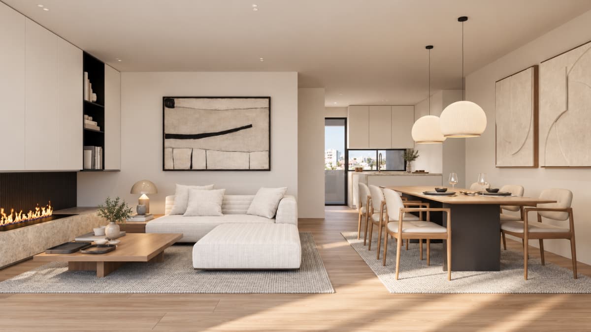 An open-plan living and dining area with a modern sectional sofa, a fireplace, a long wooden dining table, and minimalist artwork on the walls.
